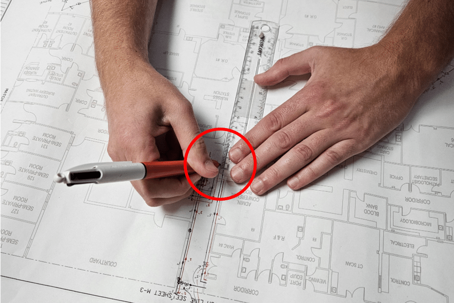 Hands Drawing on Blueprints with Red Callout Circle - The Vital Role of Accurate Piping Schematics in Food Product Processing Facilities | HydroCorp - HydroCorp